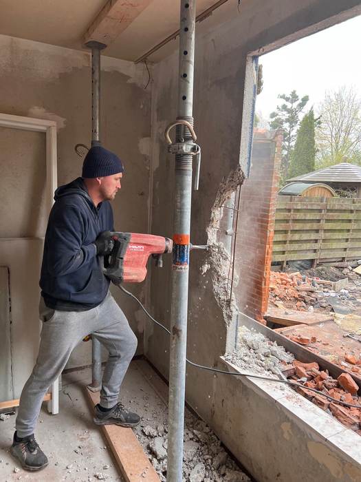 Muur doorbreken met breekhamer
